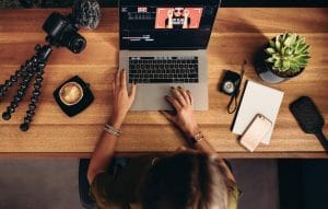 female editing videos on laptop
